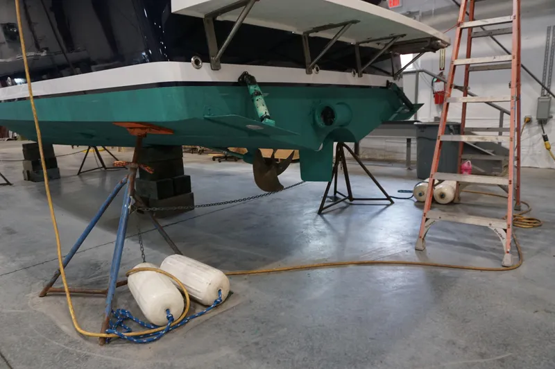 Slide: The Image of 2006 Back Cove 29 boat in a workshop, supported by stands and a ladder. - 9