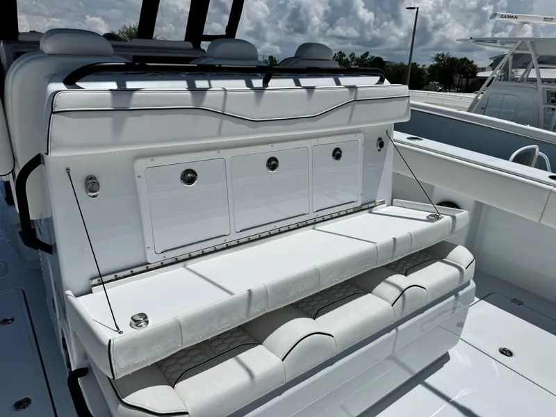 Slide: The Image of 2026 Invincible 38 Catamaran with white seating and storage compartments under a cloudy sky. - 14