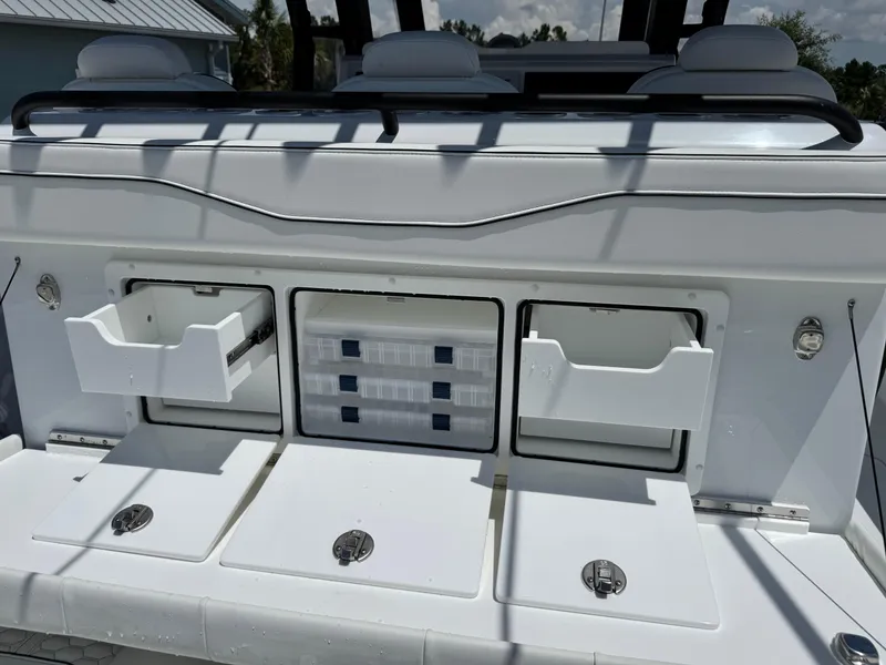 Slide: The Image of 2026 Invincible 38 Catamaran storage compartments with open drawers and latches. - 15