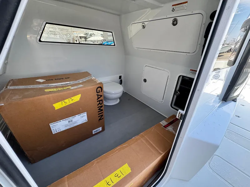 Slide: The Image of Interior of 2026 Invincible 38 Catamaran with Garmin equipment boxes and a compact toilet. - 24
