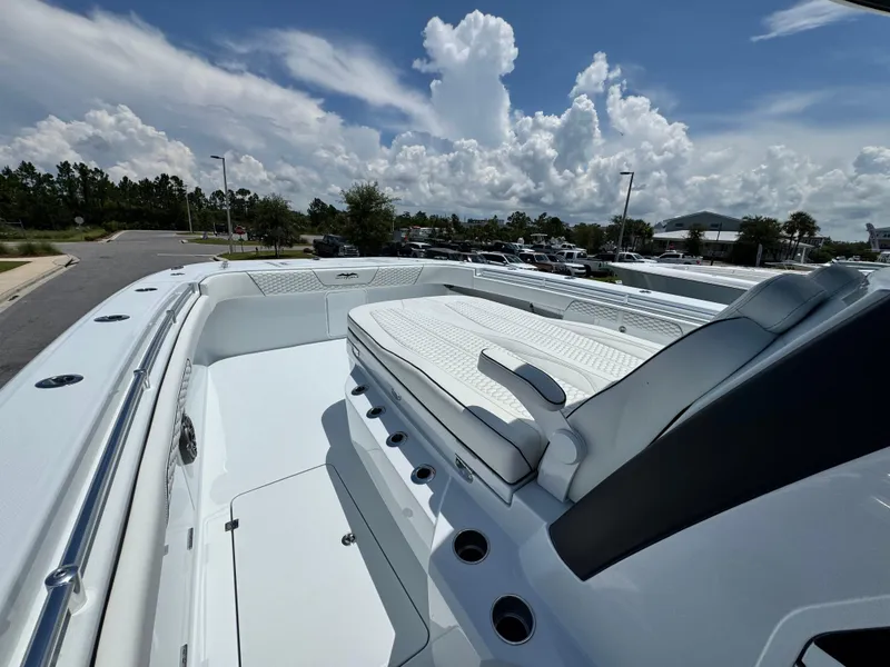 Slide: The Image of 2026 Invincible 38 Catamaran with sleek seating and modern design under a cloudy sky. - 25