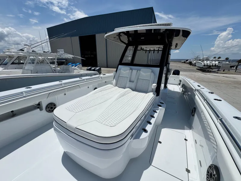 Slide: The Image of 2026 Invincible 38 Catamaran with sleek design, docked near a large warehouse. - 28