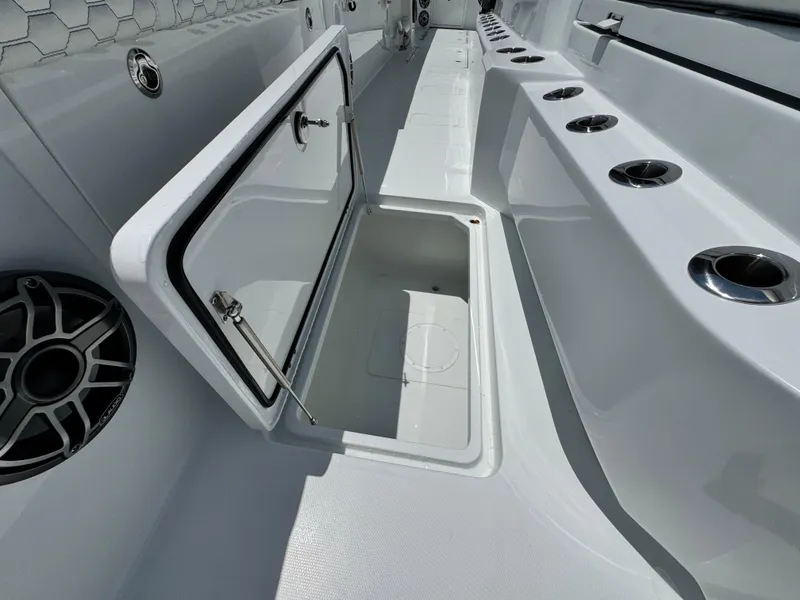 Slide: The Image of Open storage compartment on 2026 Invincible 38 Catamaran deck, featuring sleek design and cup holders. - 31