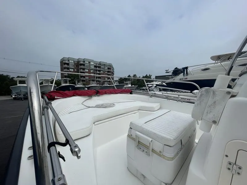 Slide: The Image of 2008 Boston Whaler 170 Montauk boat with white seating, docked near buildings. - 4