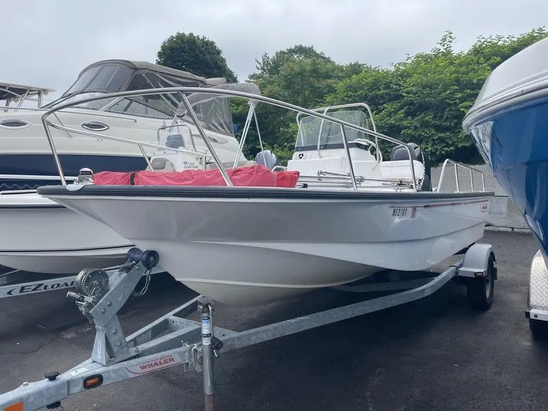 Slide: The Image of 2008 Boston Whaler 170 Montauk boat on trailer, parked among other boats. - 8