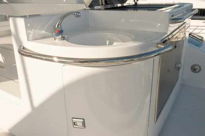 Slide: The Image of Luxury sink area on 2001 Mikelson 61 Yachtfisher, featuring sleek design and chrome fixtures. - 100