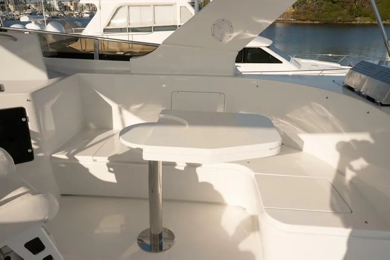 Slide: The Image of 2001 Mikelson 61 Yachtfisher deck with seating and table, docked by the water. - 101