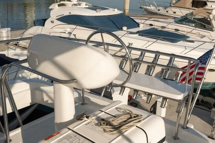 Slide: The Image of 2001 Mikelson 61 Yachtfisher helm with marina view and American flag. - 102