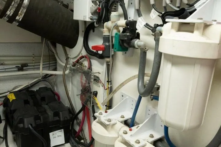 Slide: The Image of Engine room of a 2001 Mikelson 61 Yachtfisher, showcasing mechanical components and wiring. - 108