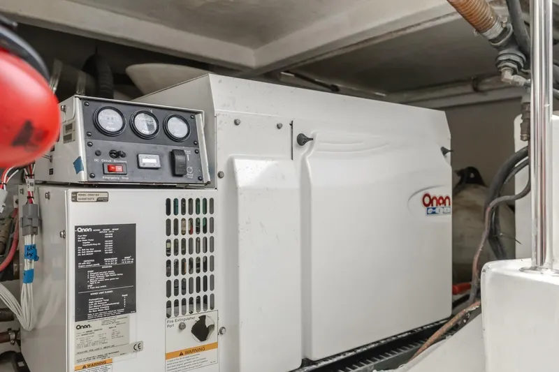 Slide: The Image of Onan generator in 2001 Mikelson 61 Yachtfisher engine room, showcasing control panel and wiring. - 111