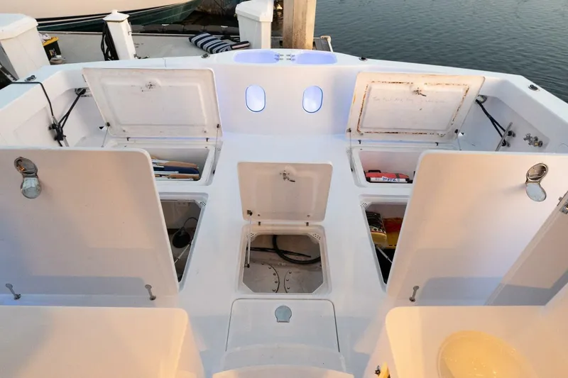 Slide: The Image of Open storage compartments on a 2001 Mikelson 61 Yachtfisher, docked by the water. - 119