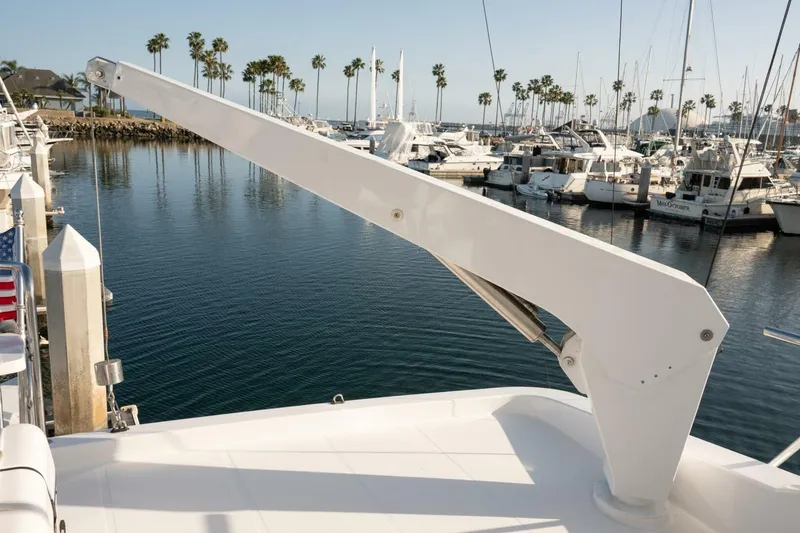 Slide: The Image of 2001 Mikelson 61 Yachtfisher at marina, featuring crane arm and scenic harbor view. - 122