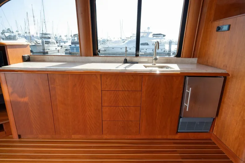 Slide: The Image of Luxurious wooden interior of 2001 Mikelson 61 Yachtfisher with sleek countertop and marina view. - 68