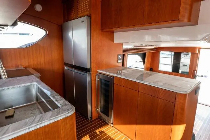 Slide: The Image of Luxurious kitchen interior of 2001 Mikelson 61 Yachtfisher with modern appliances and wood finish. - 74
