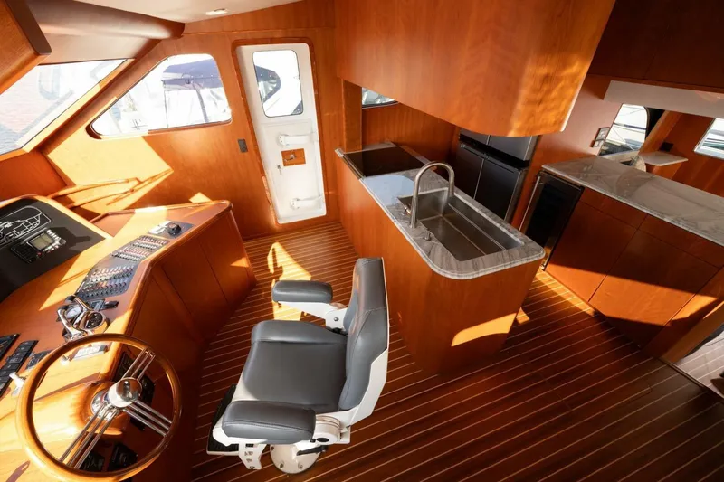 Slide: The Image of Luxurious interior of 2001 Mikelson 61 Yachtfisher with helm, kitchen, and wooden finishes. - 78