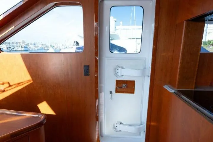 Slide: The Image of Interior view of 2001 Mikelson 61 Yachtfisher, featuring wooden paneling and a white door. - 79