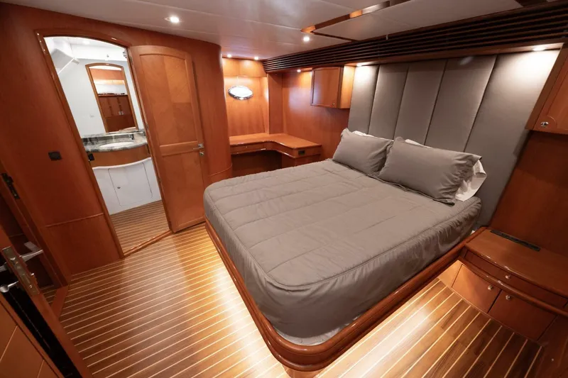 Slide: The Image of Luxurious bedroom interior of 2001 Mikelson 61 Yachtfisher with wood paneling and cozy bedding. - 86