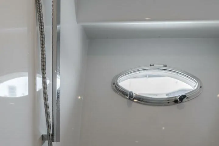 Slide: The Image of Porthole window inside 2001 Mikelson 61 Yachtfisher, showcasing sleek interior design. - 91