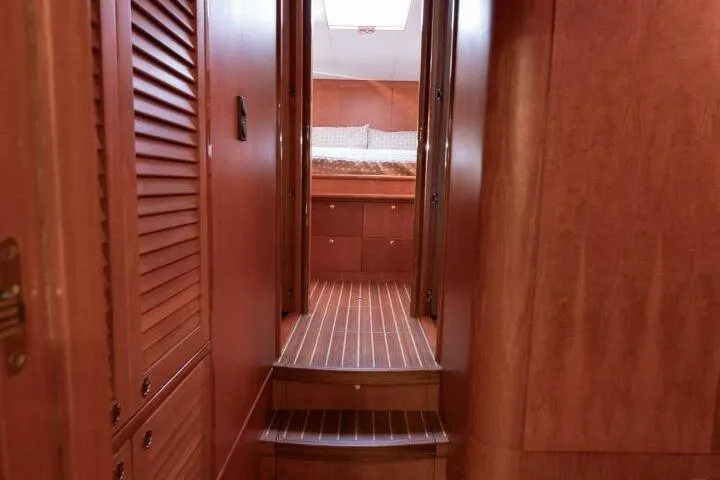 Slide: The Image of Interior of 2001 Mikelson 61 Yachtfisher, featuring wooden paneling and cozy cabin entrance. - 92