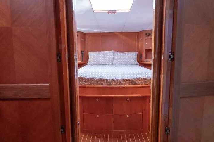 Slide: The Image of Interior cabin of 2001 Mikelson 61 Yachtfisher with wooden finish and cozy bedding. - 93