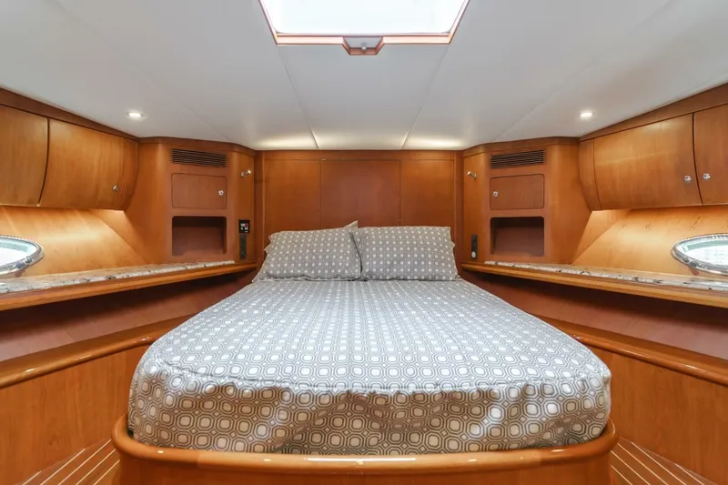 Slide: The Image of Luxurious cabin interior of 2001 Mikelson 61 Yachtfisher with wood finish and cozy bedding. - 96