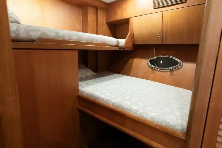 Slide: The Image of Interior cabin of 2001 Mikelson 61 Yachtfisher with wooden bunk beds and porthole. - 99