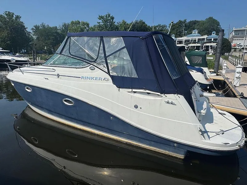 Slide: The Image of 2008 Rinker 280 Express Cruiser docked at marina, blue and white exterior. - 0
