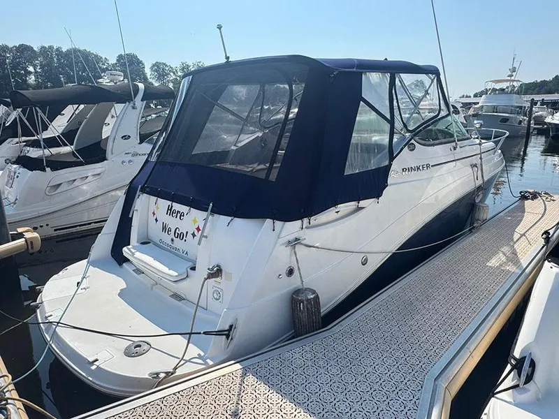 Slide: The Image of 2008 Rinker 280 Express Cruiser docked at marina, rear view with blue canopy. - 1
