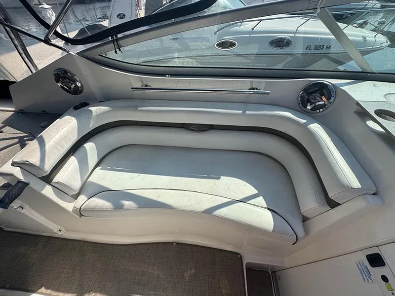 Slide: The Image of 2008 Rinker 280 Express Cruiser interior seating area with curved white cushions. - 16