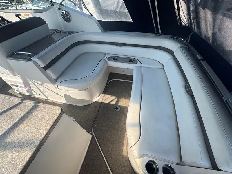 Slide: The Image of 2008 Rinker 280 Express Cruiser interior with white seating and cup holders. - 18