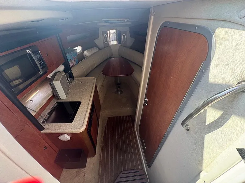 Slide: The Image of 2008 Rinker 280 Express Cruiser interior with kitchenette and seating area. - 9