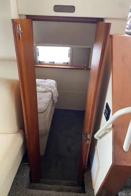Slide: The Image of Interior cabin view of a 1999 Silverton 392 Motor Yacht, featuring a cozy bed and wooden door. - 10
