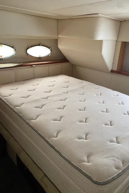 Slide: The Image of 1999 Silverton 392 Motor Yacht bedroom with mattress and porthole windows. - 11