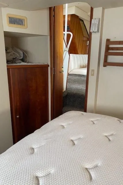 Slide: The Image of Interior of 1999 Silverton 392 Motor Yacht, featuring a cozy bedroom and wooden cabinetry. - 13
