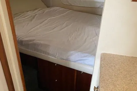 Slide: The Image of 1999 Silverton 392 Motor Yacht interior cabin with bed and wooden cabinetry. - 16