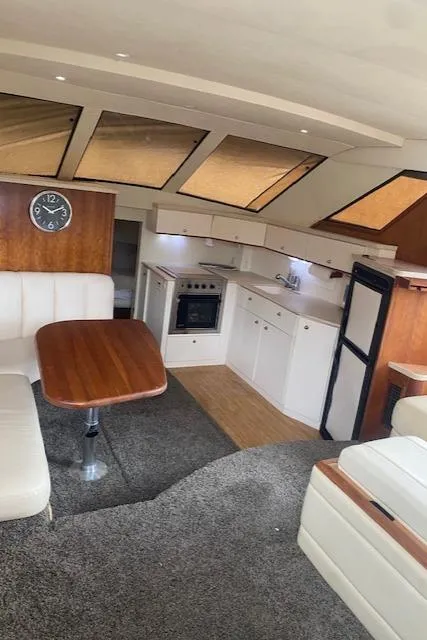 Slide: The Image of Interior of 1999 Silverton 392 Motor Yacht with kitchen, dining area, and large windows. - 18