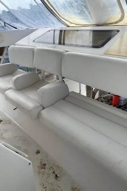 Slide: The Image of 1999 Silverton 392 Motor Yacht interior seating with white upholstery and large windows. - 4