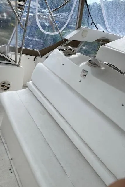 Slide: The Image of 1999 Silverton 392 Motor Yacht interior with white seating and clear canopy. - 5