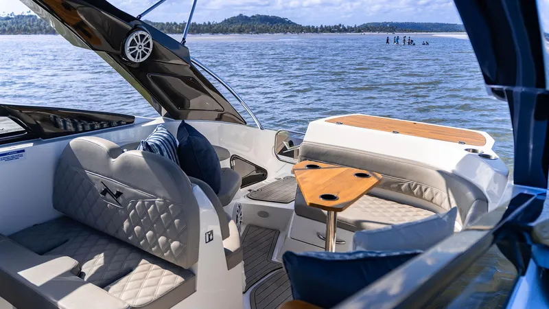 Slide: The Image of Luxurious interior of 2025 NX Boats NX260 EVOLUTION on a serene water backdrop. - 2