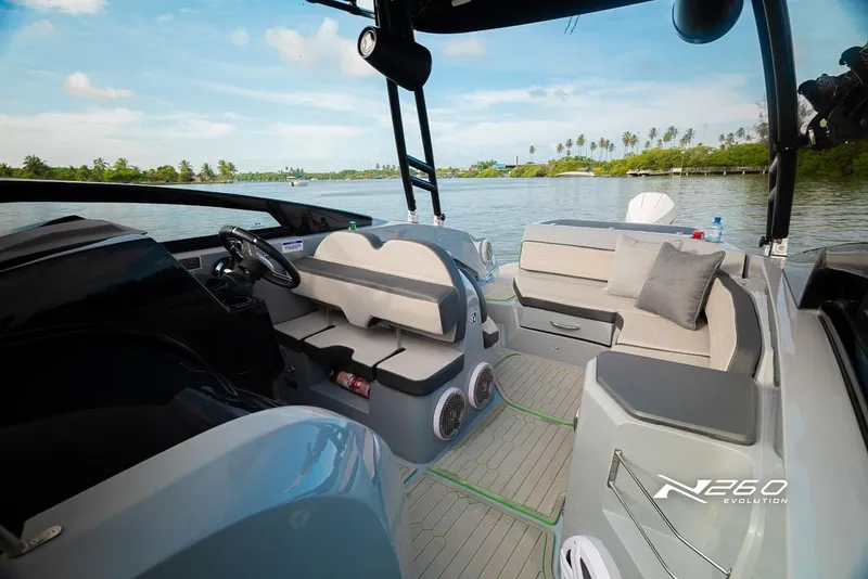 Slide: The Image of 2025 NX Boats NX260 EVOLUTION interior with modern seating and scenic water view. - 8