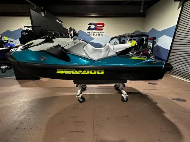 Slide: The Image of 2025 Sea-Doo GTI SE 170 jet ski in showroom, teal and black design. - 10