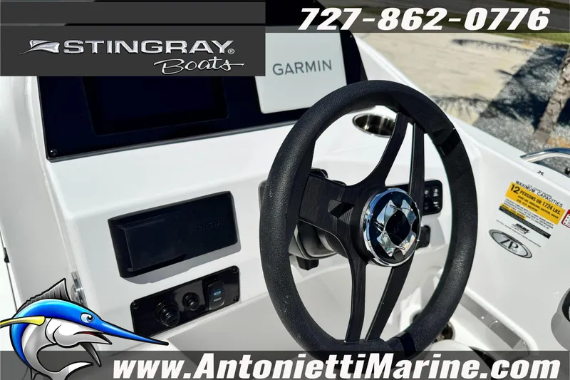 Slide: The Image of 2026 Stingray 212 SC boat dashboard with steering wheel and Garmin display. - 22