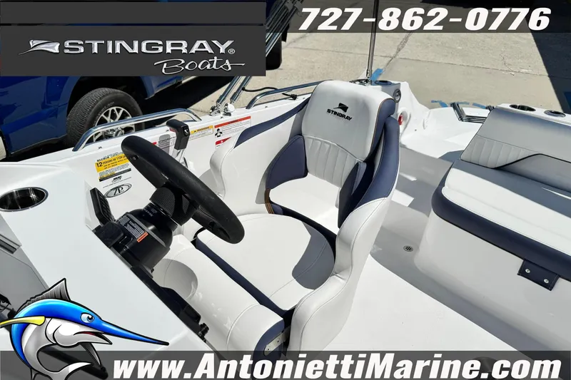 Slide: The Image of 2026 Stingray 212 SC boat interior with steering wheel and seating, featuring marine branding. - 28