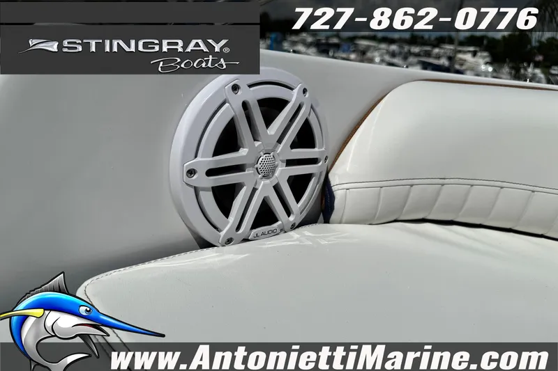 Slide: The Image of 2026 Stingray 212 SC boat interior with JL Audio speaker, white seating, and branding details. - 30