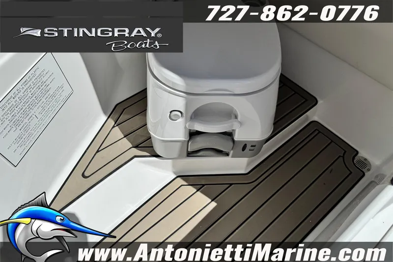 Slide: The Image of 2026 Stingray 212 SC boat interior with portable toilet and marine flooring. - 33