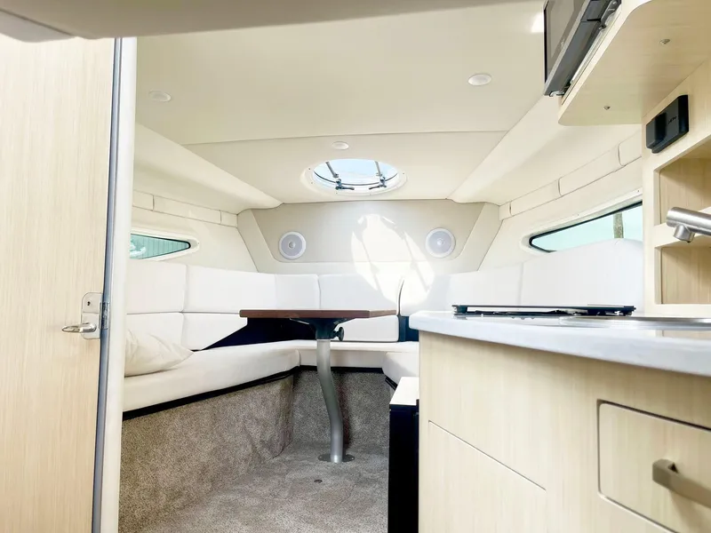 Slide: The Image of 2024 Regal 26XO boat interior with modern kitchen and cozy seating area. - 12