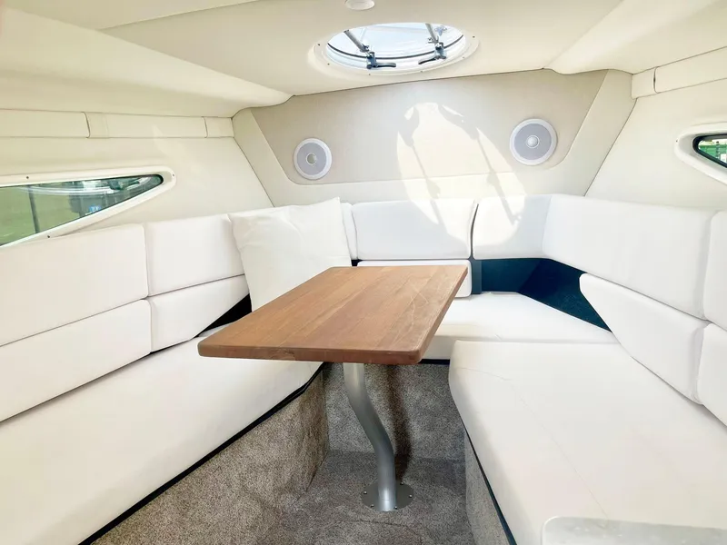 Slide: The Image of 2024 Regal 26XO boat interior with white seating and wooden table. - 13
