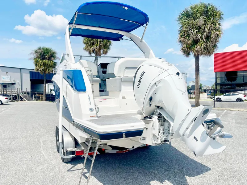 Slide: The Image of 2024 Regal 26XO boat with Yamaha engine, parked outdoors under blue sky. - 3
