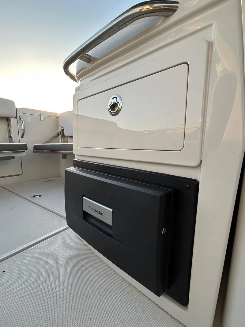 Slide: The Image of 2024 Crownline 260DC boat interior with storage compartment and Dometic unit. - 10