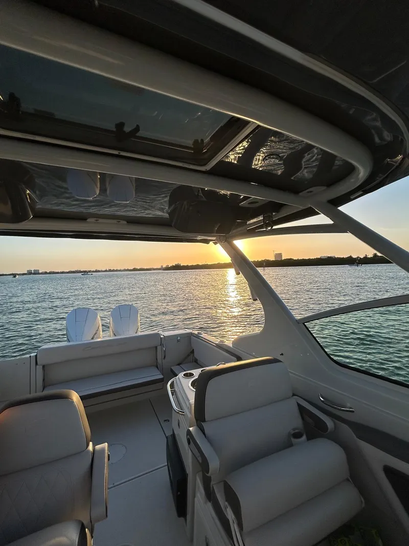 Slide: The Image of 2024 Crownline 260DC boat interior with sunset view over the water. - 13